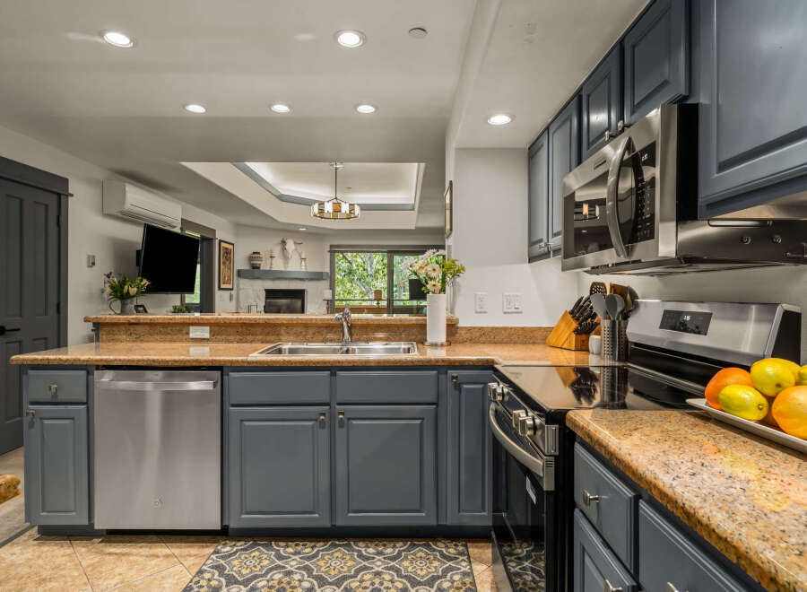 Discover this beautifully updated kitchen featuring sleek, dark gray cabinetry complemented by a stunning granite countertop.