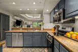 Discover this beautifully updated kitchen featuring sleek, dark gray cabinetry complemented by a stunning granite countertop.