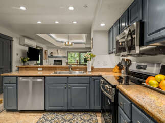Discover this beautifully updated kitchen featuring sleek, dark gray cabinetry complemented by a stunning granite countertop.