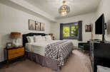 Experience ultimate comfort in this beautifully appointed bedroom, featuring a plush king-size bed adorned with crisp white linens and a striking geometric-patterned throw.
