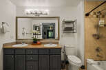 This spacious bathroom features a double vanity with ample counter space and dark gray cabinetry, perfect for storage.