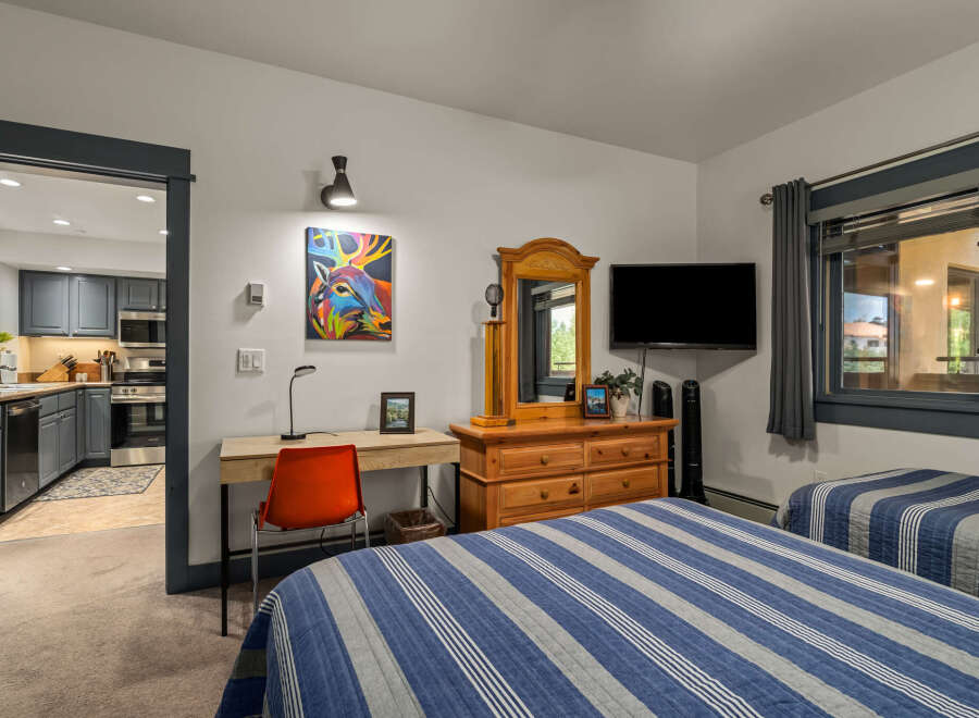 This inviting bedroom features two comfortable beds with blue and white striped comforters, perfect for a restful night's sleep.