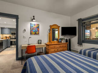 This inviting bedroom features two comfortable beds with blue and white striped comforters, perfect for a restful night's sleep.