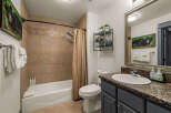 This charming bathroom features a spacious bathtub with a decorative shower curtain and tiled walls, perfect for a relaxing soak.
