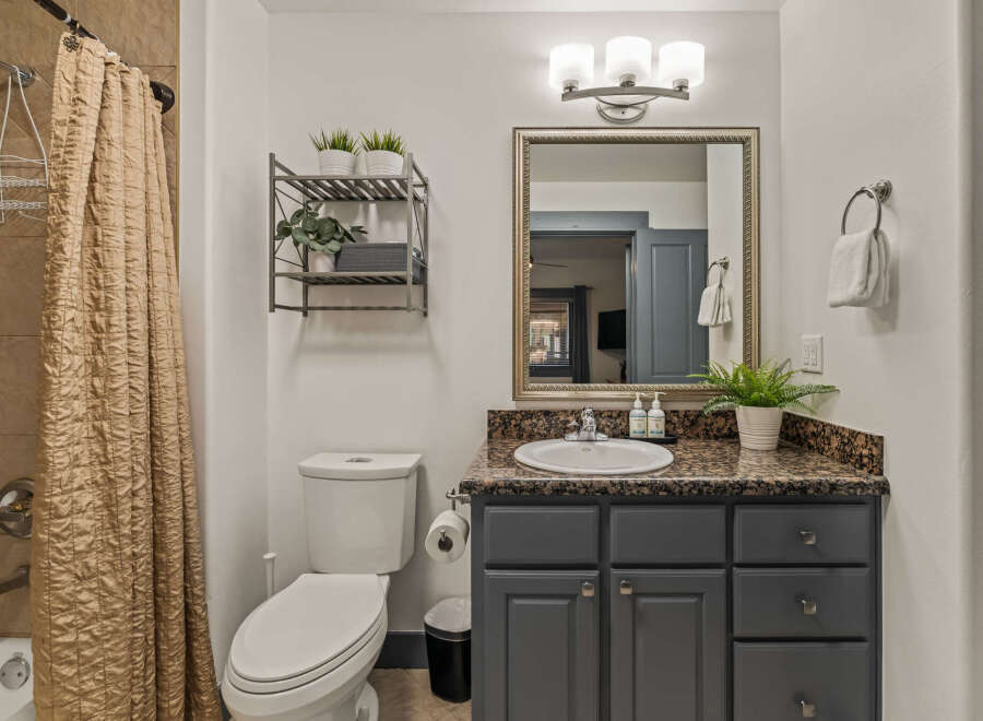 This modern bathroom features a stylish vanity with a granite countertop and ample storage.