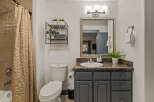 This modern bathroom features a stylish vanity with a granite countertop and ample storage.