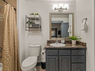 This modern bathroom features a stylish vanity with a granite countertop and ample storage.