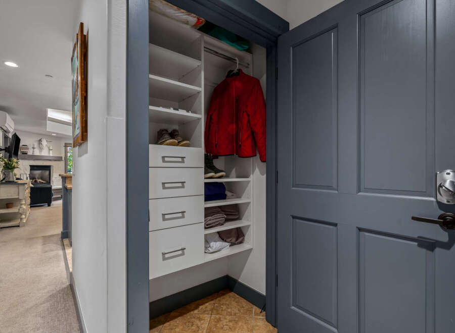 Discover ample storage solutions in this home, featuring a well-organized closet with shelving and drawers perfect for stowing away essentials.