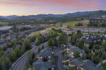 Experience luxury mountain living in this stunning aerial view of a residential community nestled amidst rolling hills and majestic peaks.