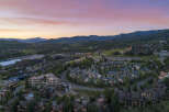 Experience luxury mountain living in this stunning aerial view of a residential community nestled amidst rolling hills and majestic peaks.
