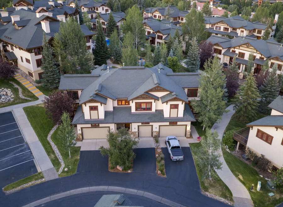 Experience luxury mountain living in this stunning multi-unit property, featuring a classic alpine architectural style with dark pitched roofs and warm wood accents.