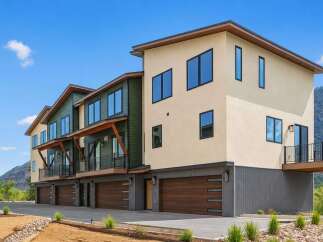 Discover modern living in this stunning multi-unit property, featuring contemporary architecture with a mix of stucco and green siding.