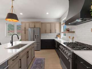 Experience modern luxury in this stunning kitchen, featuring a spacious island with a deep sink and sleek black faucet.