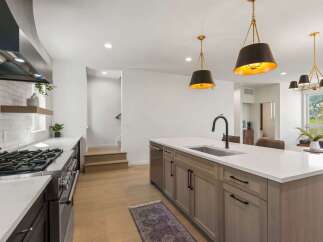 Experience modern luxury in this stunning kitchen, featuring a spacious island with a sleek faucet and ample counter space.