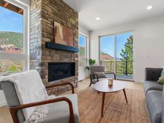 Experience breathtaking mountain views from this stunning living room, featuring a magnificent stone fireplace as the centerpiece.