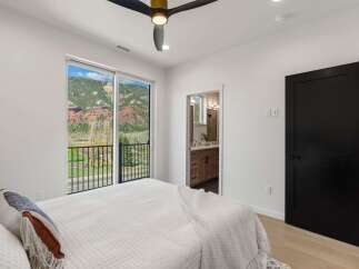 Experience breathtaking mountain views from this stunning bedroom, featuring a spacious sliding glass door that opens to a private balcony.