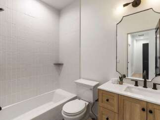 This modern bathroom features a sleek white subway tile shower and a deep soaking tub, perfect for relaxation.
