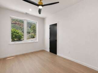 Experience breathtaking natural beauty from this stunning bedroom, featuring a large window with panoramic views of lush greenery and majestic red rock formations.