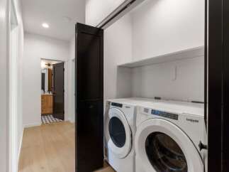 Discover modern convenience in this home featuring a dedicated laundry space with a stacked washer and dryer.