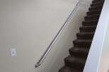 Enhance your home's safety and accessibility with this sturdy metal handrail, perfectly complementing the carpeted stairs.