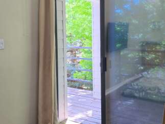 Step outside onto a charming wooden deck, perfect for enjoying the lush greenery and fresh air.
