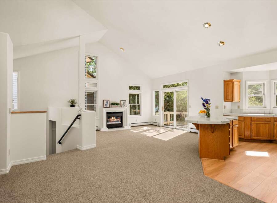 Experience open-concept living in this stunning home featuring a vaulted ceiling and a cozy fireplace as the centerpiece of the living area.