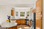 This charming kitchen features warm oak cabinetry and a spacious bay window that floods the space with natural light.