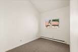Discover this charming room featuring a vaulted ceiling and a large window that floods the space with natural light.