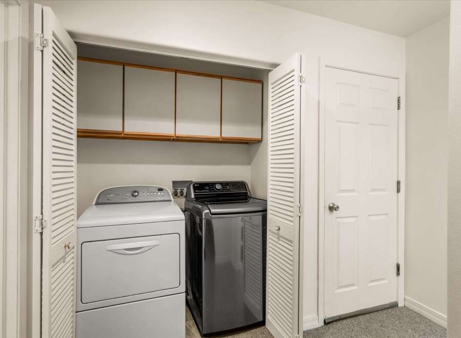This laundry closet features a stacked Whirlpool dryer and an LG washer, offering a convenient space for your laundry needs.