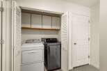 This laundry closet features a stacked Whirlpool dryer and an LG washer, offering a convenient space for your laundry needs.