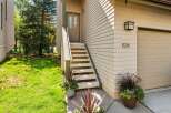 Welcome to this charming home featuring a welcoming front entrance with a light beige door and two glass panes, leading up a set of stairs.