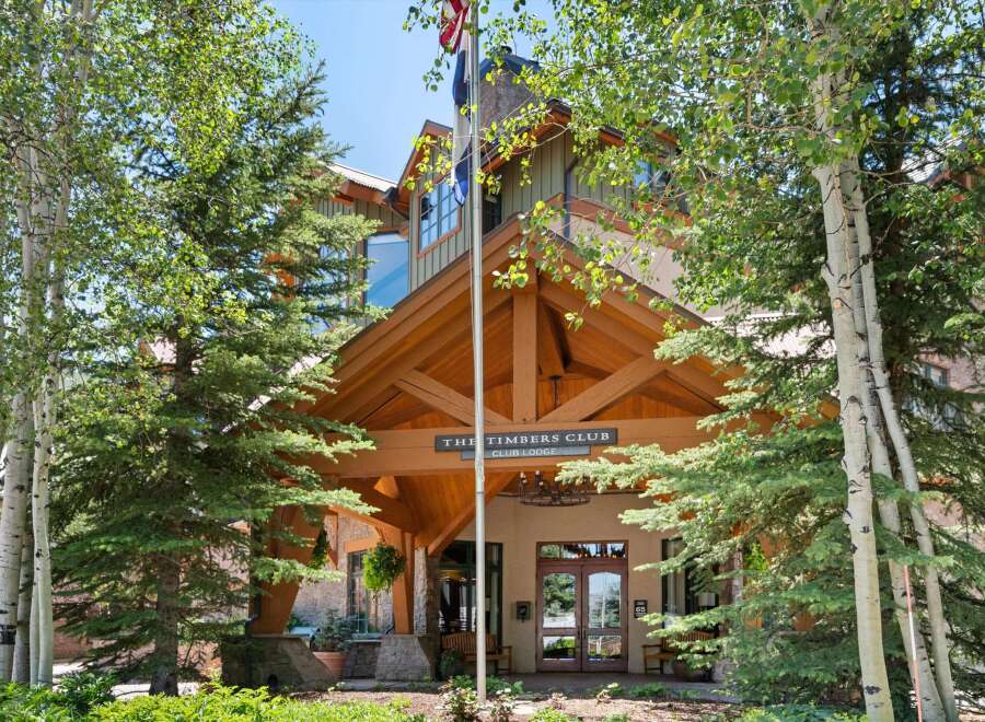 Experience the charm of The Timbers Club, a distinguished club lodge nestled amidst lush greenery and towering trees.