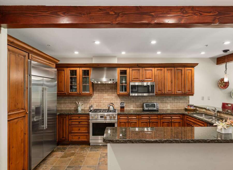 Experience culinary excellence in this stunning kitchen, featuring rich wood cabinetry and sleek stainless steel appliances.