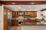 Experience culinary excellence in this stunning kitchen, featuring rich wood cabinetry and sleek stainless steel appliances.