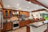 Experience luxury mountain living in this stunning kitchen, featuring rich cherry wood cabinetry, granite countertops, and a professional-grade stainless steel range.