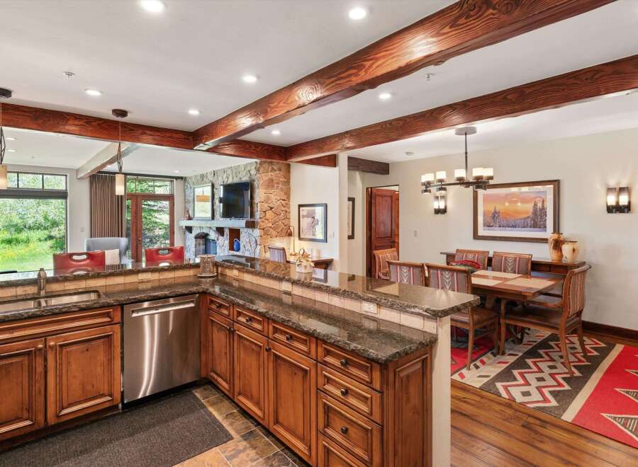 Experience rustic charm in this open-concept living space, featuring a well-appointed kitchen with granite countertops and custom wood cabinetry.