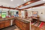 Experience rustic charm in this open-concept living space, featuring a well-appointed kitchen with granite countertops and custom wood cabinetry.