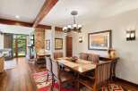 Experience rustic elegance in this dining room, featuring a substantial wooden dining table set for six, complemented by chairs upholstered in a Native American-inspired fabric.