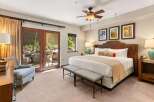 Experience luxurious comfort in this spacious bedroom, featuring a king-size bed with a plush headboard and elegant decorative pillows.