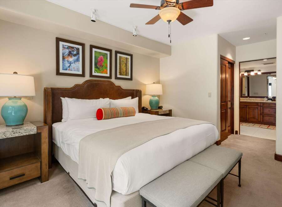Experience ultimate comfort in this luxurious bedroom, featuring a king-size bed with a plush leather headboard and elegant bedside lamps.