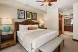 Experience ultimate comfort in this luxurious bedroom, featuring a king-size bed with a plush leather headboard and elegant bedside lamps.