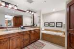 Indulge in luxury in this spacious bathroom featuring a deep soaking tub, perfect for unwinding after a long day.
