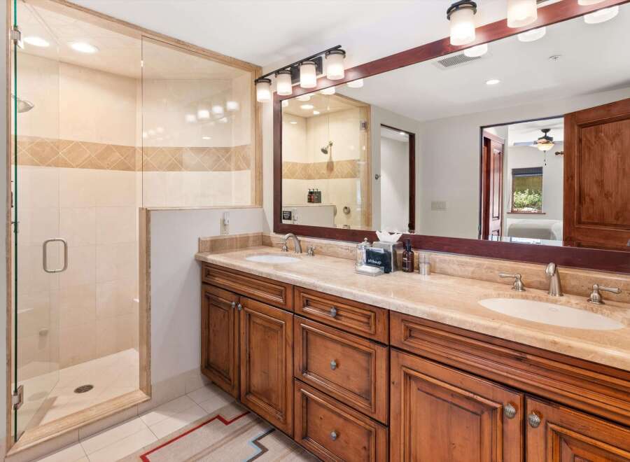 This luxurious bathroom features a spacious glass-enclosed shower with elegant tilework and a modern showerhead.