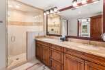 This luxurious bathroom features a spacious glass-enclosed shower with elegant tilework and a modern showerhead.