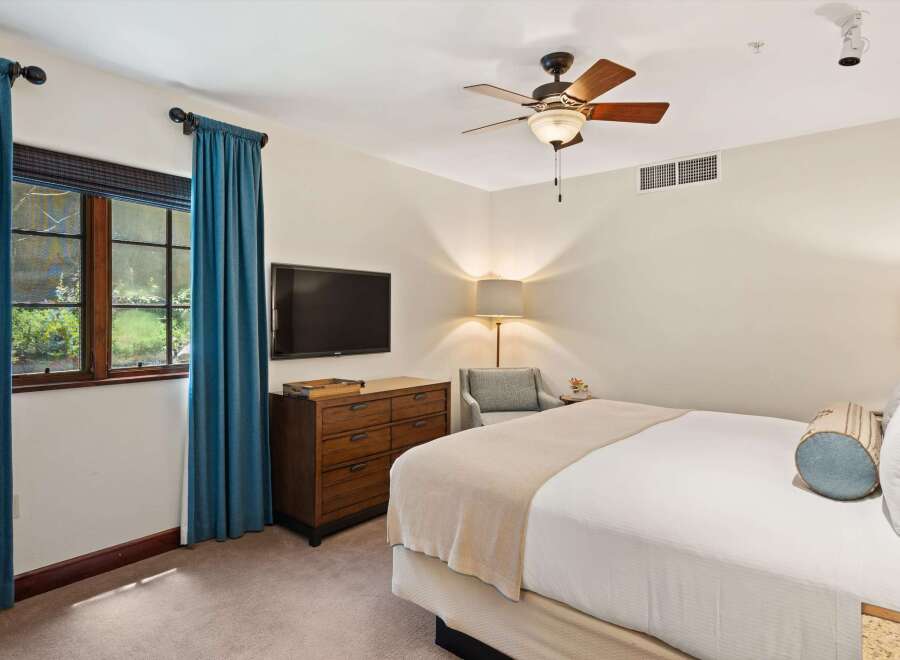 Experience comfort and style in this inviting bedroom, featuring a plush bed adorned with decorative pillows and a cozy throw.
