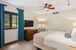Experience comfort and style in this inviting bedroom, featuring a plush bed adorned with decorative pillows and a cozy throw.