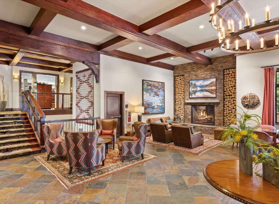 Experience rustic elegance in this inviting lodge lobby, featuring a grand stone fireplace and exposed wooden beams.