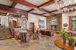 Experience rustic elegance in this inviting lodge lobby, featuring a grand stone fireplace and exposed wooden beams.