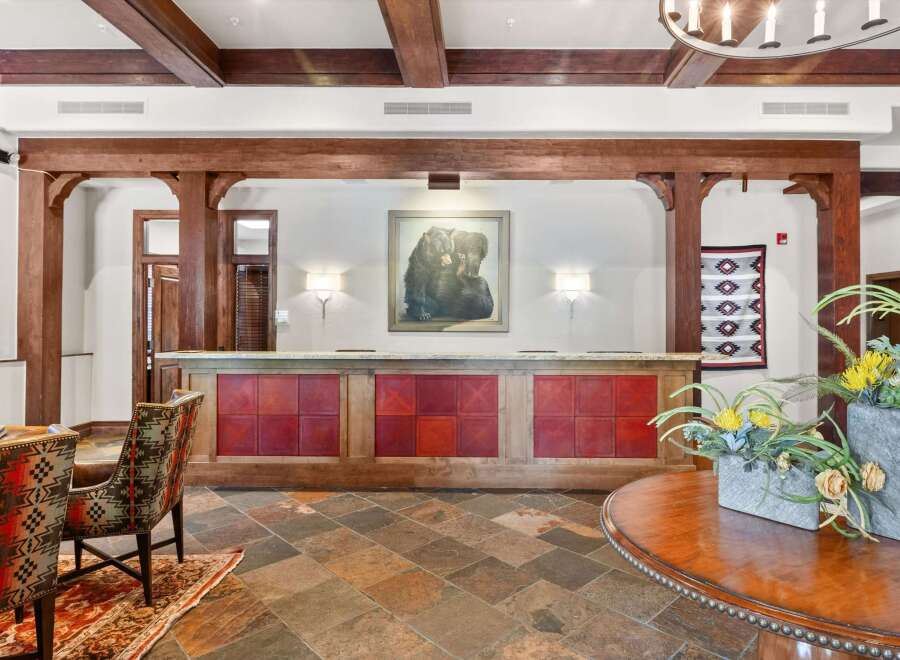 Experience a warm welcome at this lodge-inspired reception area, featuring rustic wooden beams and a charming bear-themed artwork.
