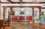 Experience a warm welcome at this lodge-inspired reception area, featuring rustic wooden beams and a charming bear-themed artwork.